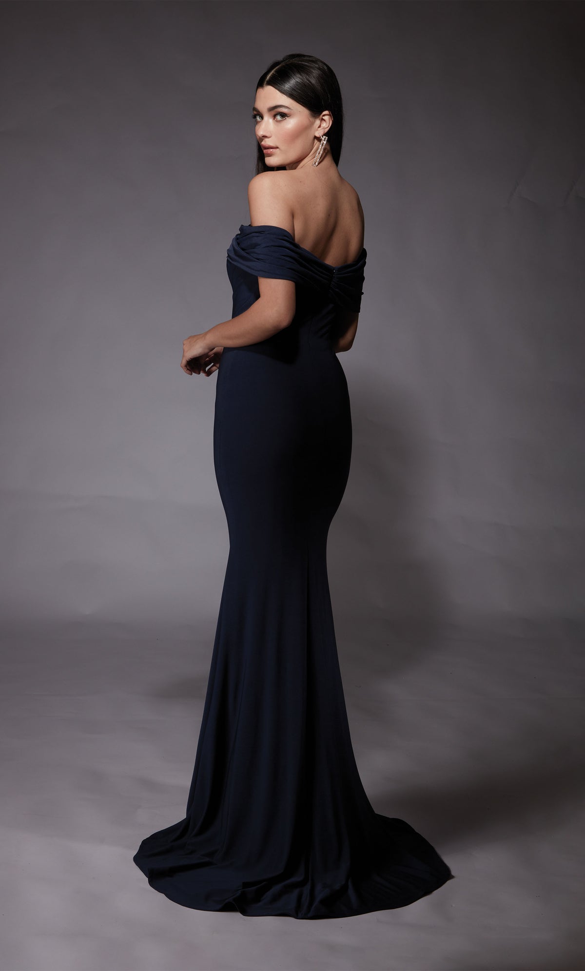 A navy evening gown with an off the shoulder neckline and fit an flare silhouette and a slight train. The dress was crafted from a gorgeous Italian Jersey fabric.