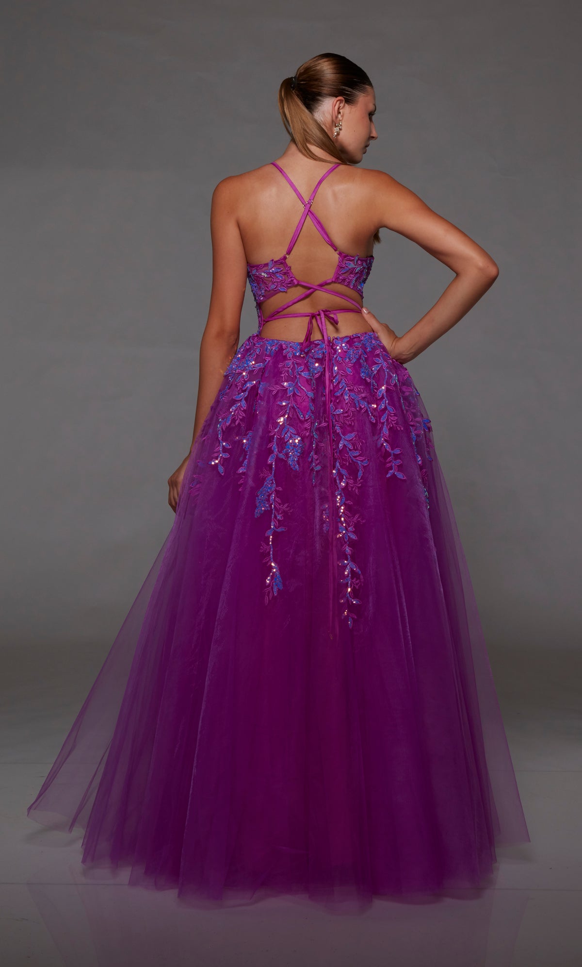 Purple prom dress: sheer corset bodice, full tulle skirt with front slit, lace-up back, and intricate floral lace appliques for an enchanting look.