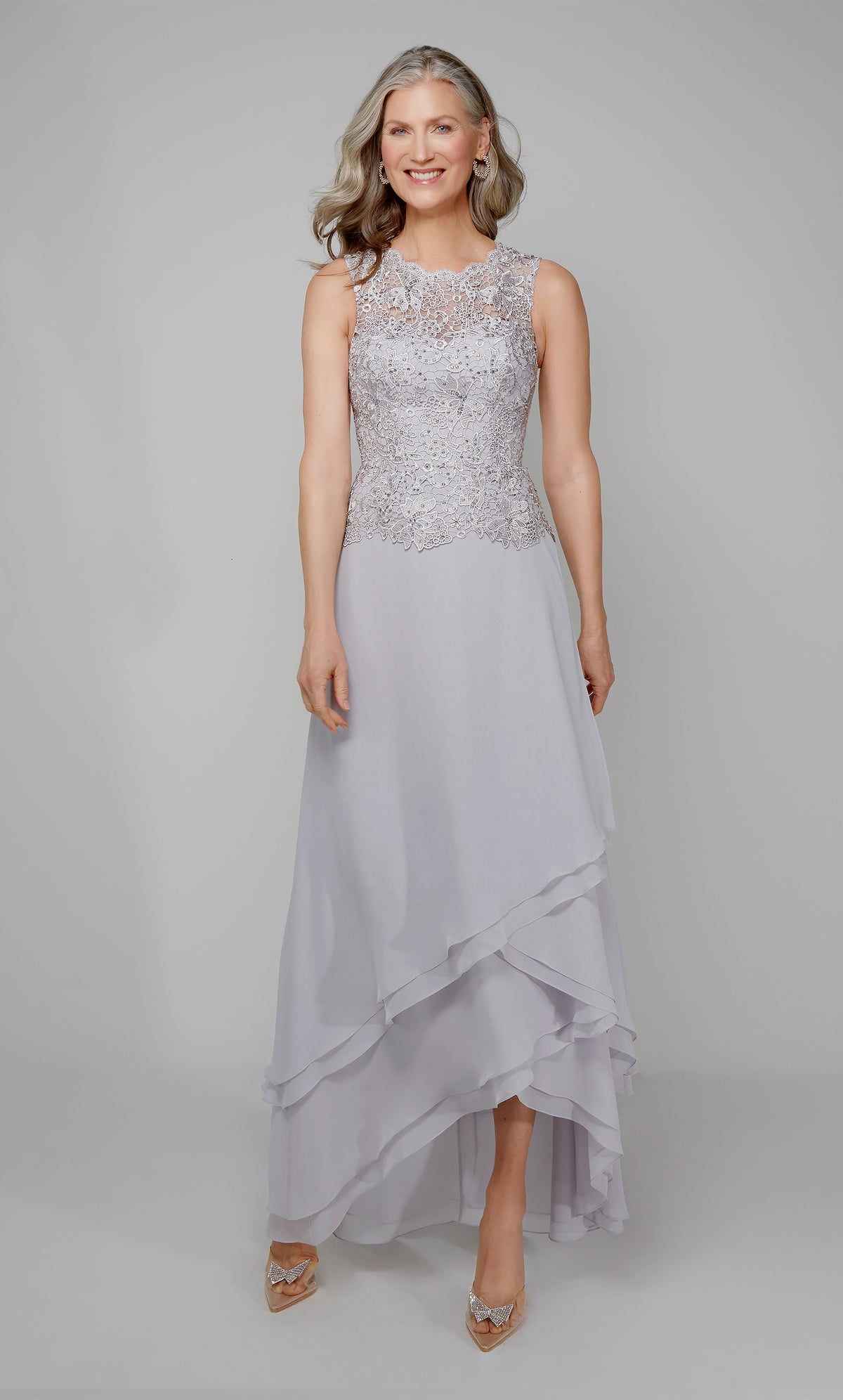 Flowy chiffon formal dress with a lace bodice and tiered skirt in silver.