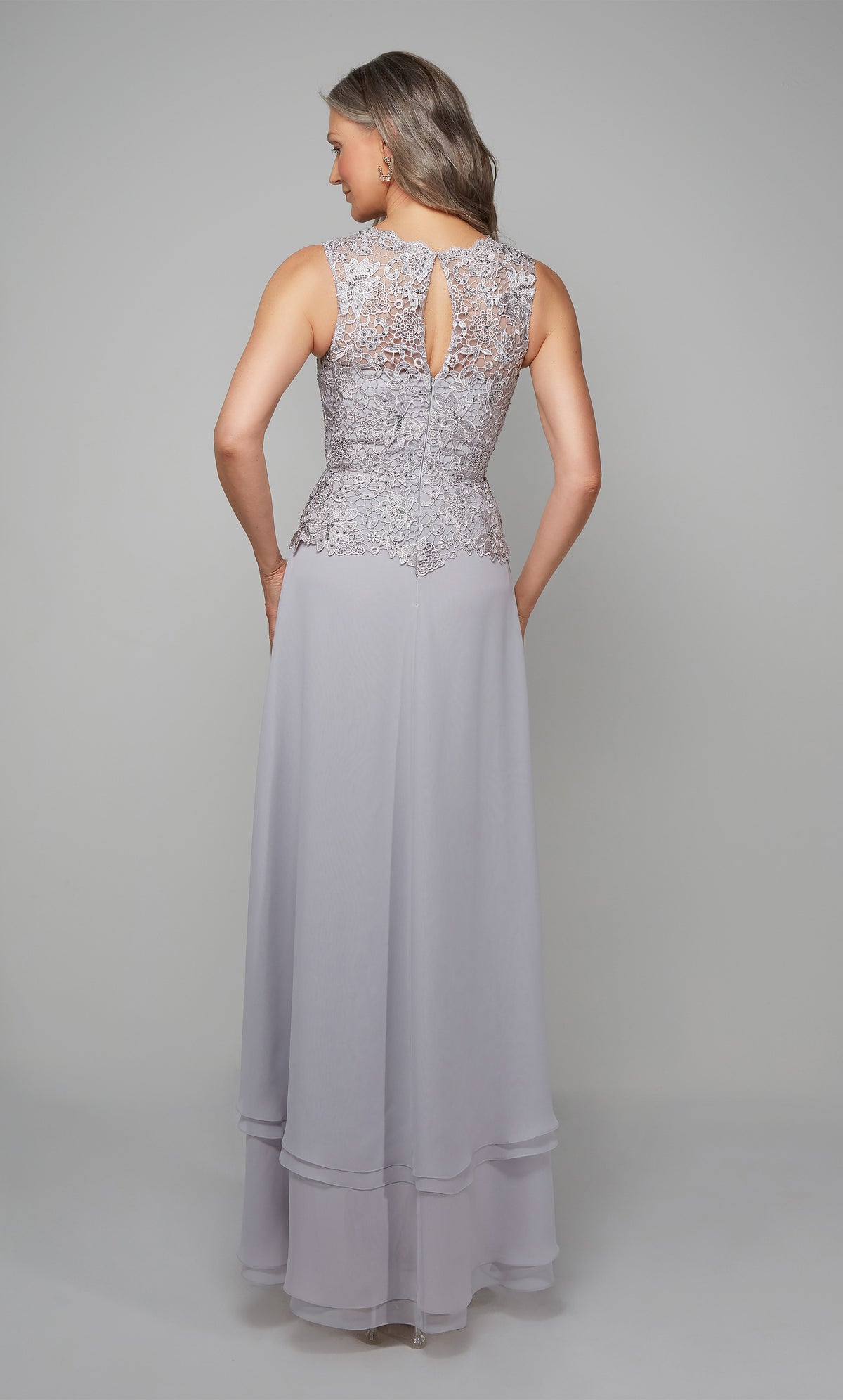 Flowy chiffon formal dress with a lace bodice, keyhole back detail, and tiered skirt in silver.