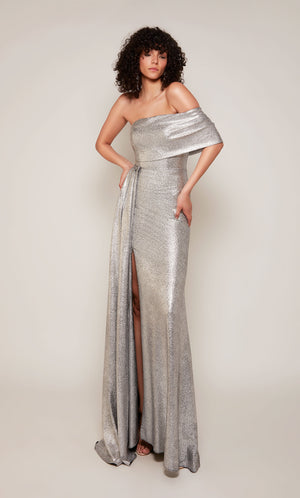 A silver evening gown boasting a one shoulder neckline, a front slit, and a detachable side drape.