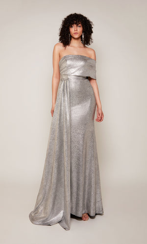 A silver evening gown boasting a one shoulder neckline, a front slit, and a detachable side drape.