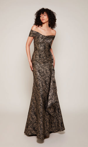 A black and gold Jacquard formal gown with an off the shoulder, twist neckline and a cascading side ruffle.