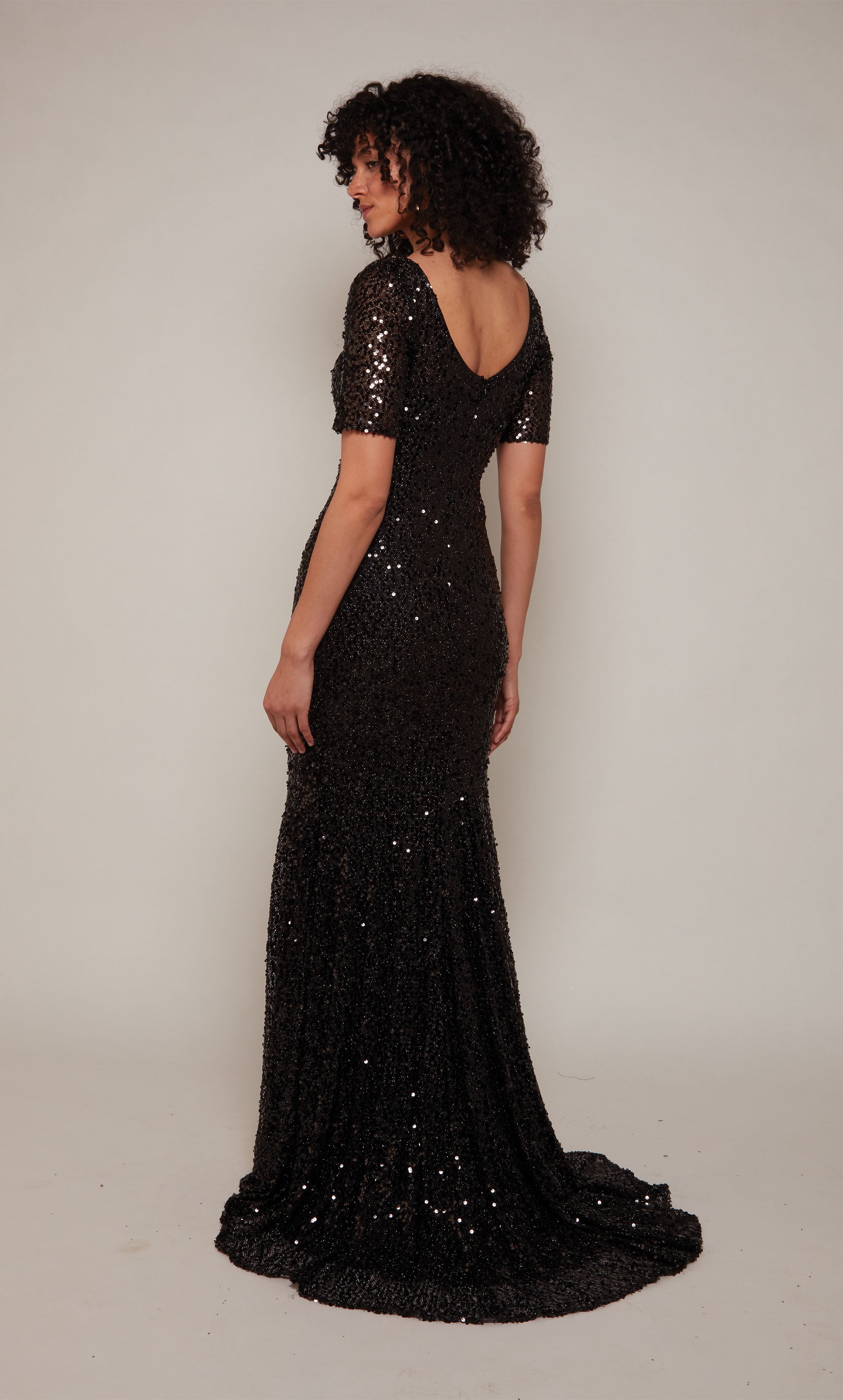 A classic black mother of the bride dress with a V-neckline, short sleeves, and train crafted in a mesh sequin fabric.