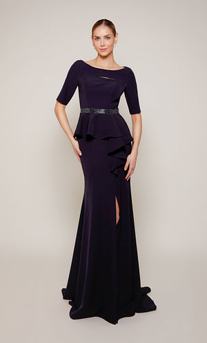 A navy scooped neck designer gown with a peplum short sleeve bodice, a beaded waistline, a side ruffle, and side slit.