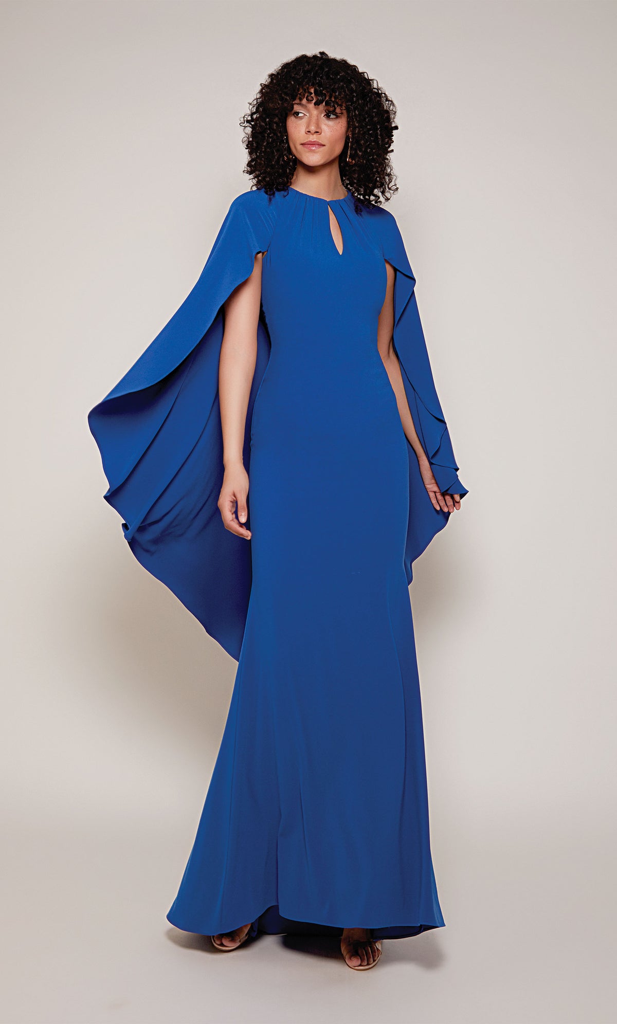 A long, fitted capelet dress with a front key hole and slightly flared skirt from knee to hemline in royal blue.