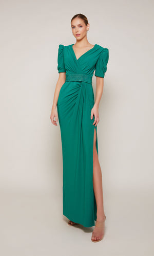 An emerald evening gown with puff sleeves, a V-neckline, an embellished belt, and elegant side slit.