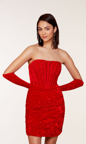 An 80's inspired red velvet corset dress with a strapless neckline and a ruched skirt. The matching gloves level up this chic look.