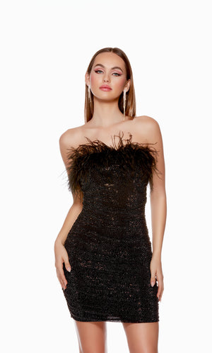 A stretch mesh strapless tube dress adorned with sparkly stones and feather trim in classic black.