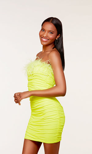 A stretch mesh strapless tube dress adorned with sparkly stones, ruching detail, and feather trim in a bright neon-green.