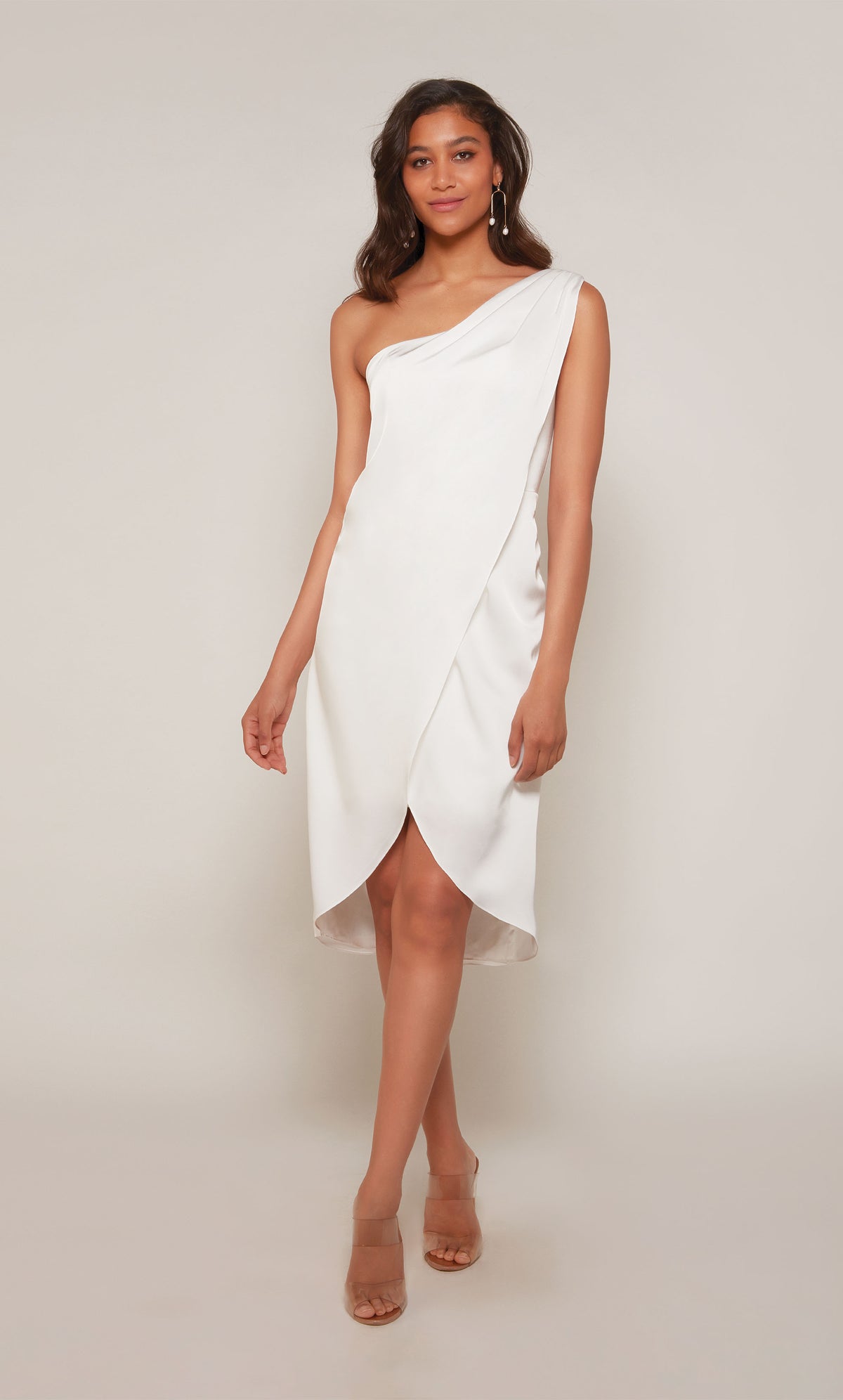 A satin wedding dress with a one shoulder neckline and an asymmetrical hemline in diamond white.