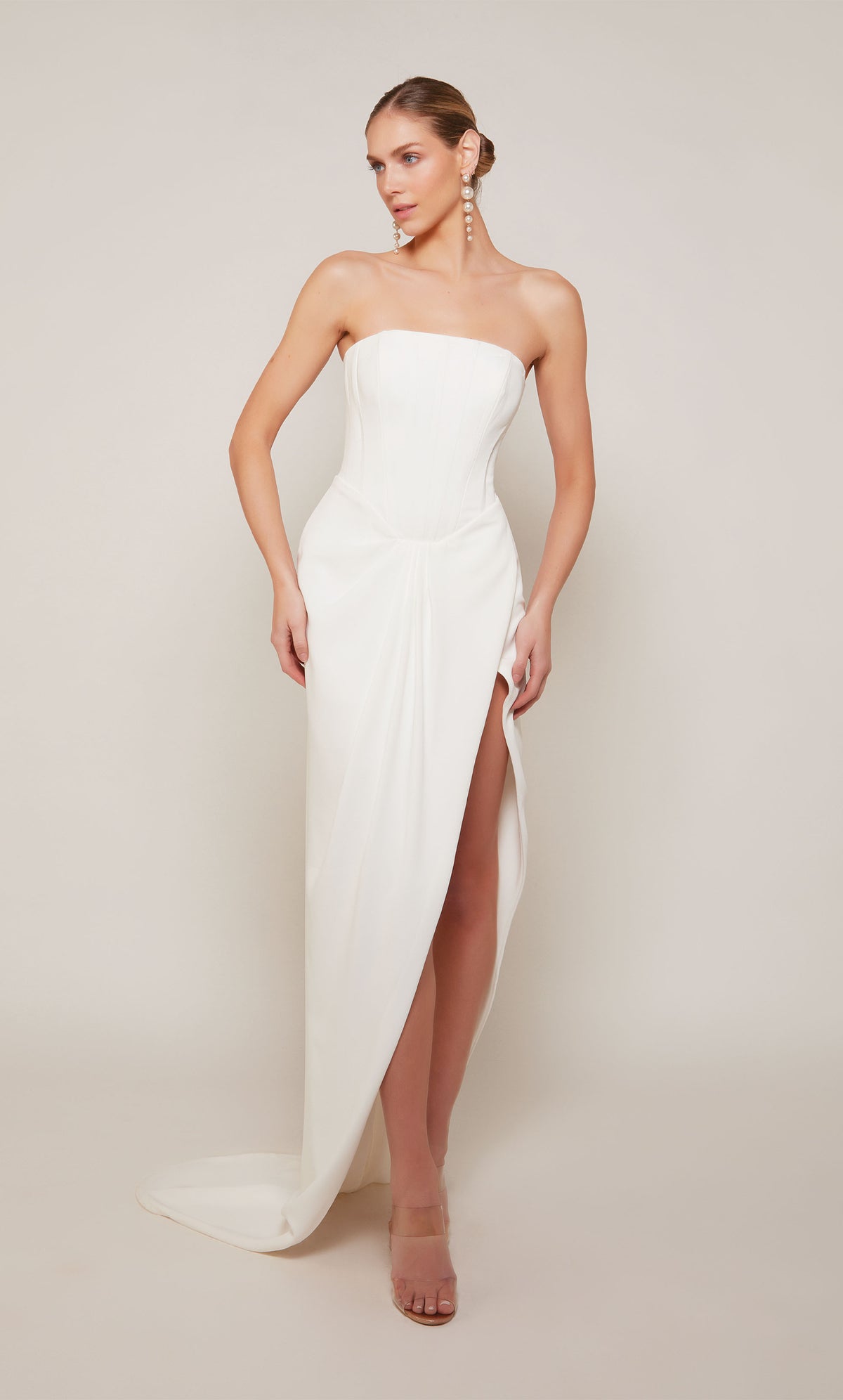 A modern corset wedding dress with a high-low hemline and slight train in ivory.