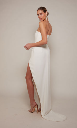 A modern corset wedding dress with a high-low hemline and slight train in ivory.