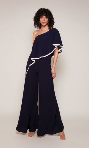 A wide leg, formal jumpsuit with a one shoulder neckline and draped bodice in navy blue with ivory trim.