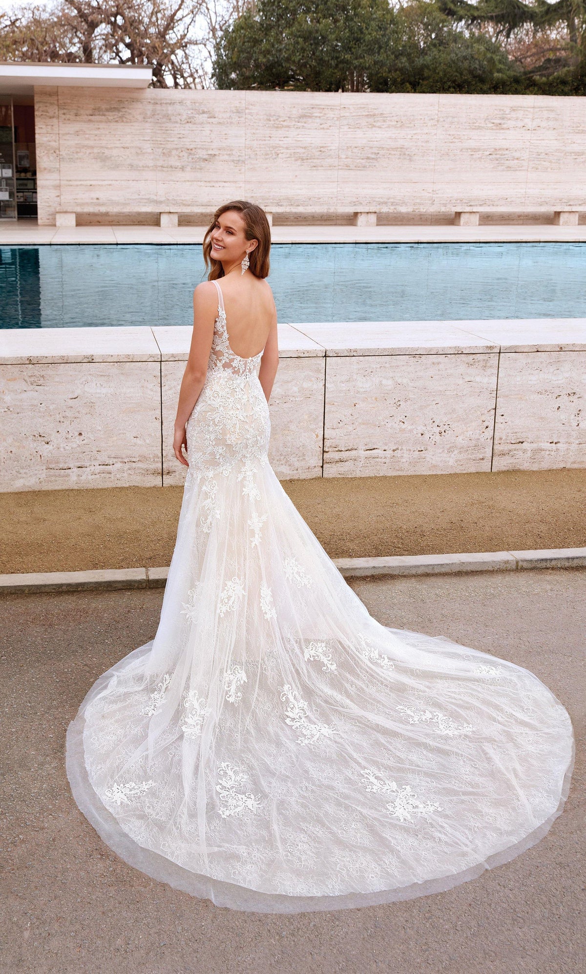 Fit and flare ivory-champagne lace wedding dress featuring a low scoop back, buttons and train