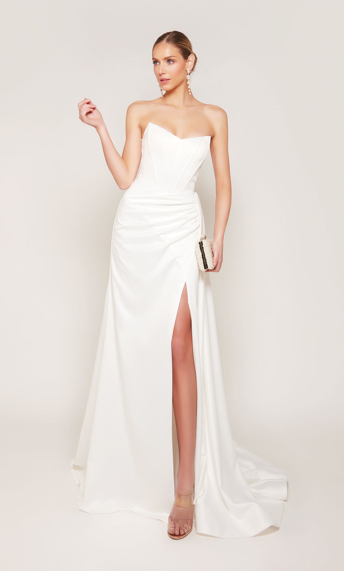 A strapless, corset wedding dress with a ruched waist, an elegant side slit, and detachable side train for a dramatic effect.