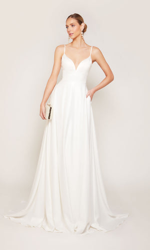 A simple, satin wedding dress with a V-neckline, side slit, and pockets. 