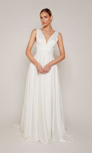 Simple satin A-line wedding dress in diamond white with a plunging neckline, open back, and satin covered buttons on the elegant train.