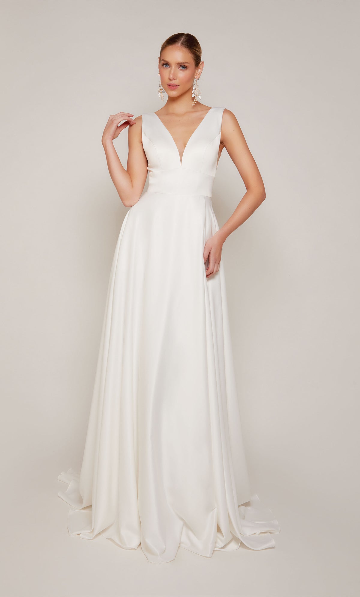 Simple satin A-line wedding dress in diamond white with a plunging neckline, open back, and satin covered buttons on the elegant train.