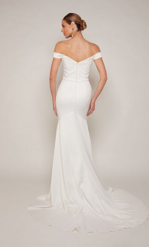 A sophisticated, off-the-shoulder satin wedding dress with a detachable train and satin-covered buttons 