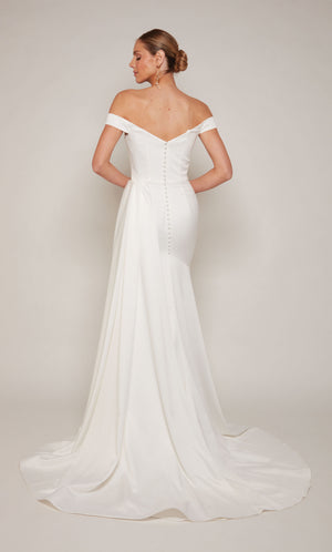 A sophisticated, off-the-shoulder satin wedding dress with a detachable train and satin-covered buttons 