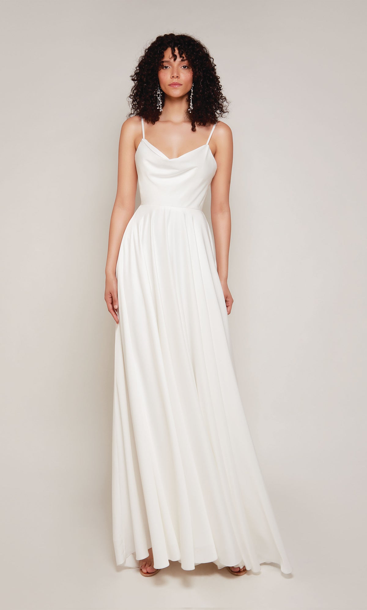 A simple wedding dress in white satin with an A-line skirt, V-shaped cowl neckline, and adjustable spaghetti straps.