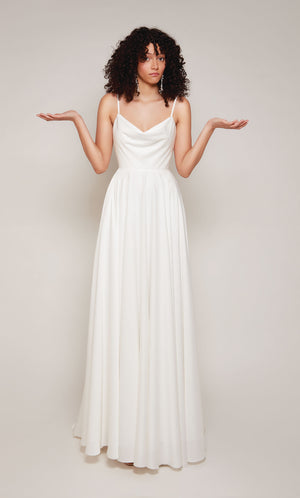 A simple wedding dress in white satin with an A-line skirt, V-shaped cowl neckline, and adjustable spaghetti straps.